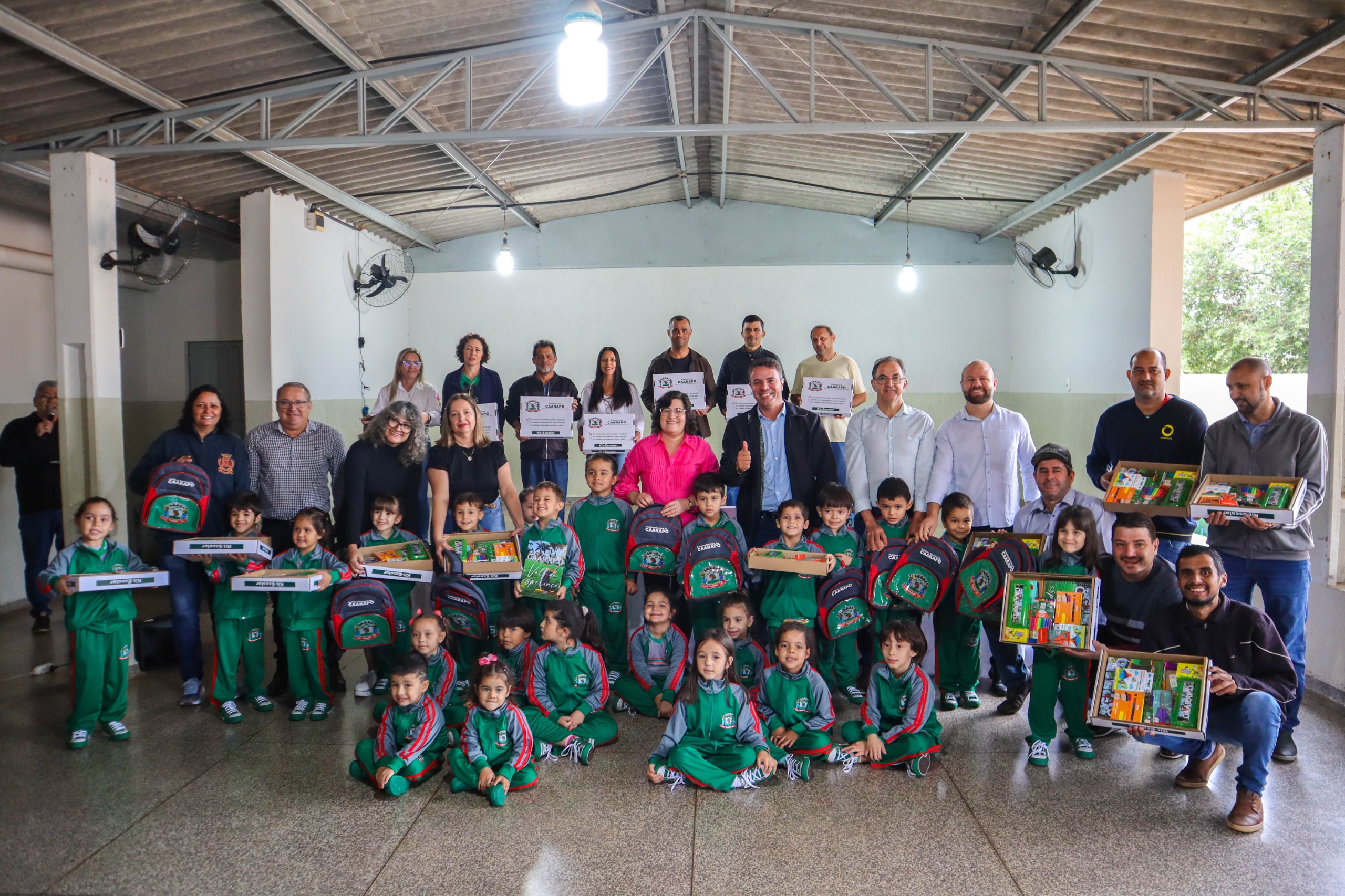 Autoridades municipais e estudantes da educação infantil na cerimônia de entrega dos kits de material e uniformes escolares no CMEI Dona China, em Caarapó